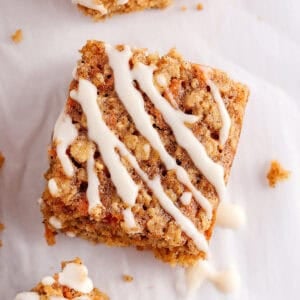 These EASY Healthy Carrot Cake Oatmeal Breakfast Bars make a quick on-the-go breakfast, snack or wholesome dessert! Made with zero refined sugar and drizzled with a delicious maple cream cheese frosting.