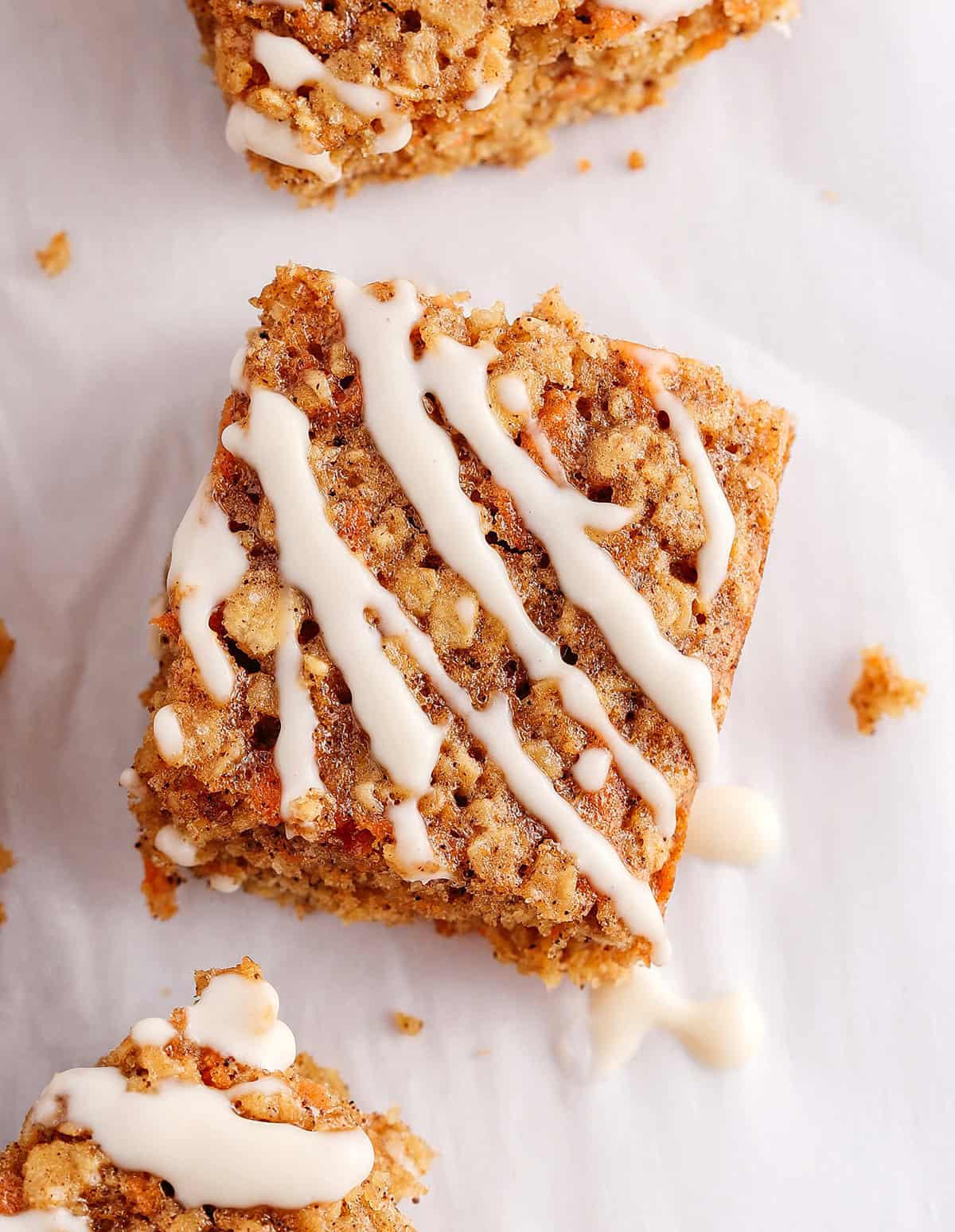 These EASY Healthy Carrot Cake Oatmeal Breakfast Bars make a quick on-the-go breakfast, snack or wholesome dessert! Made with zero refined sugar and drizzled with a delicious maple cream cheese frosting.