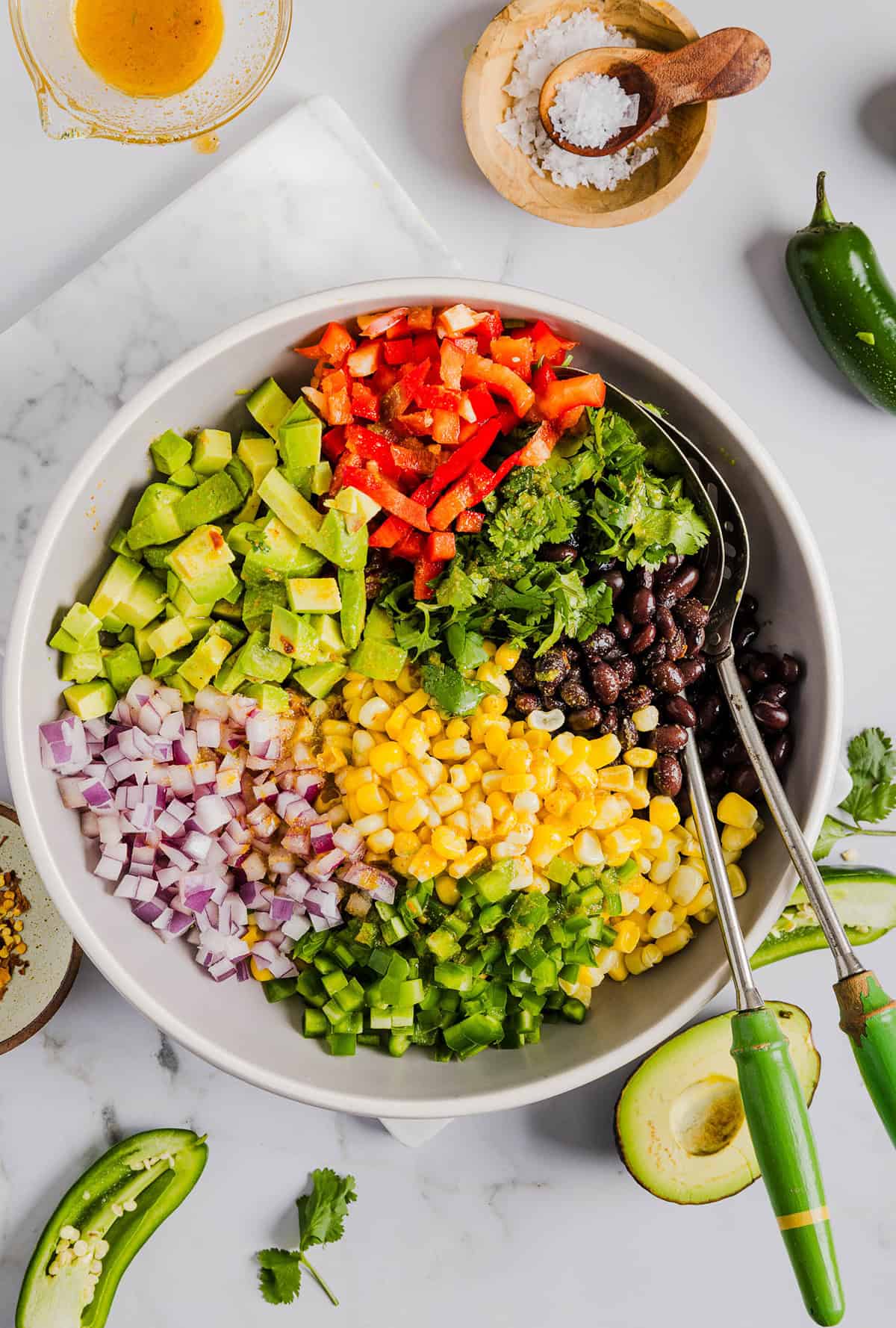This Black Bean and Corn Salad is loaded with crisp veggies, delicious spices and fresh cilantro, all tossed together in a zesty lime dressing making it the perfect summer side dish or dip!