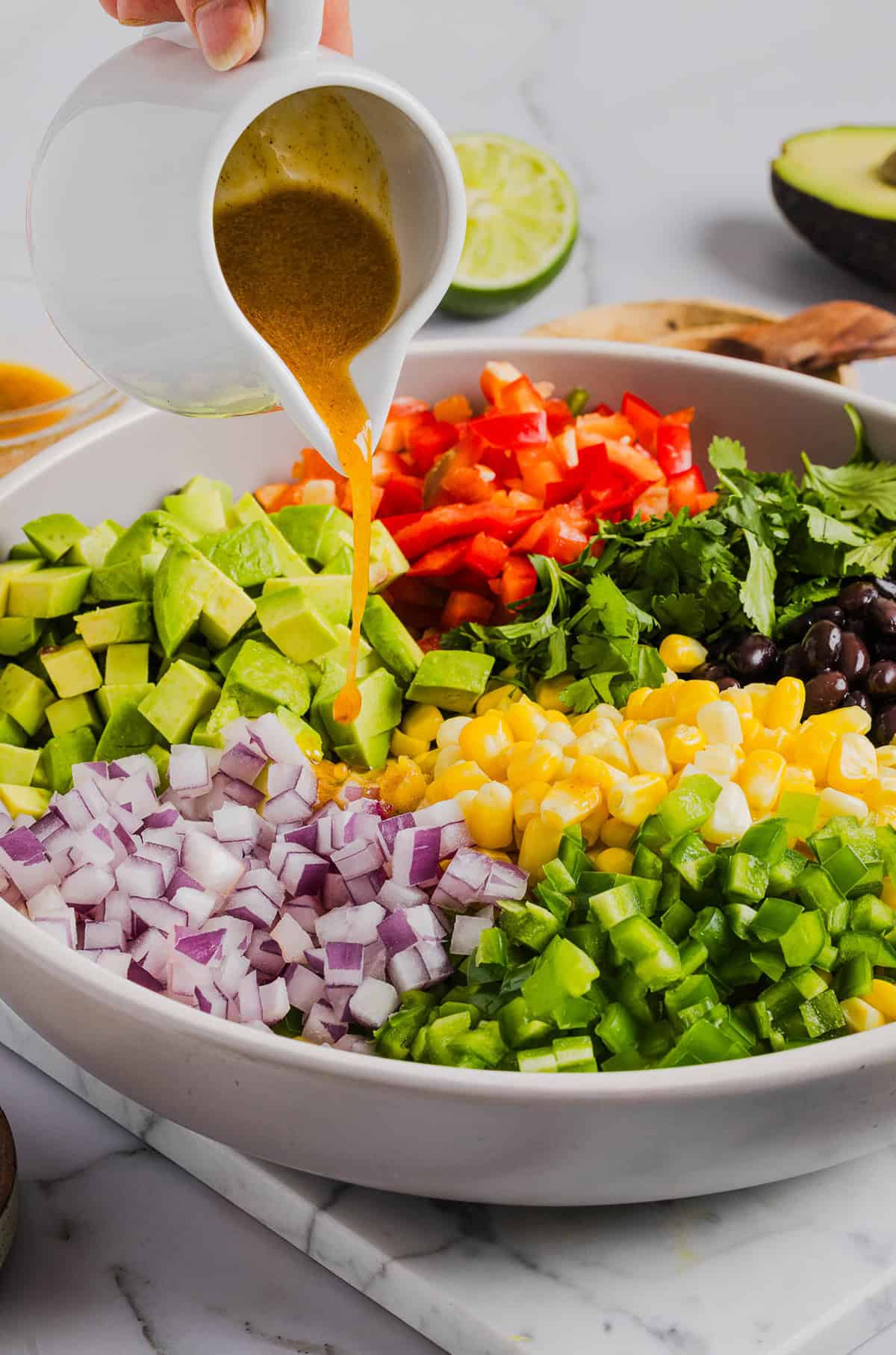 This Black Bean and Corn Salad is loaded with crisp veggies, delicious spices and fresh cilantro, all tossed together in a zesty lime dressing making it the perfect summer side dish or dip!