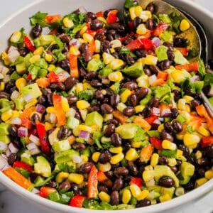 This Black Bean and Corn Salad is loaded with crisp veggies, delicious spices and fresh cilantro, all tossed together in a zesty lime dressing making it the perfect summer side dish or dip!