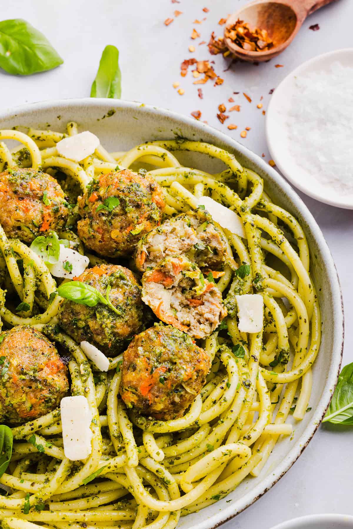 Mouthwatering Baked Chicken Pesto Meatballs made with tender ground chicken, garlicky basil pesto, fresh veggies and parmesan cheese. Juicy, flavorful and make the perfect weeknight meal served over pasta or with rice!