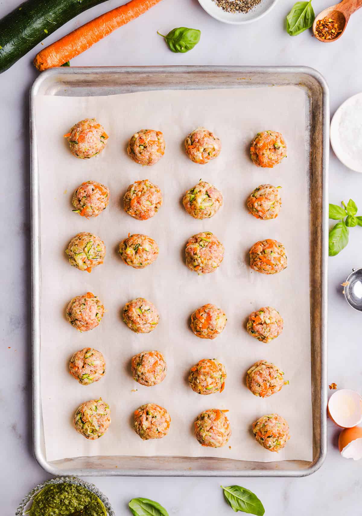 Mouthwatering Baked Chicken Pesto Meatballs made with tender ground chicken, garlicky basil pesto, fresh veggies and parmesan cheese. Juicy, flavorful and make the perfect weeknight meal served over pasta or with rice!