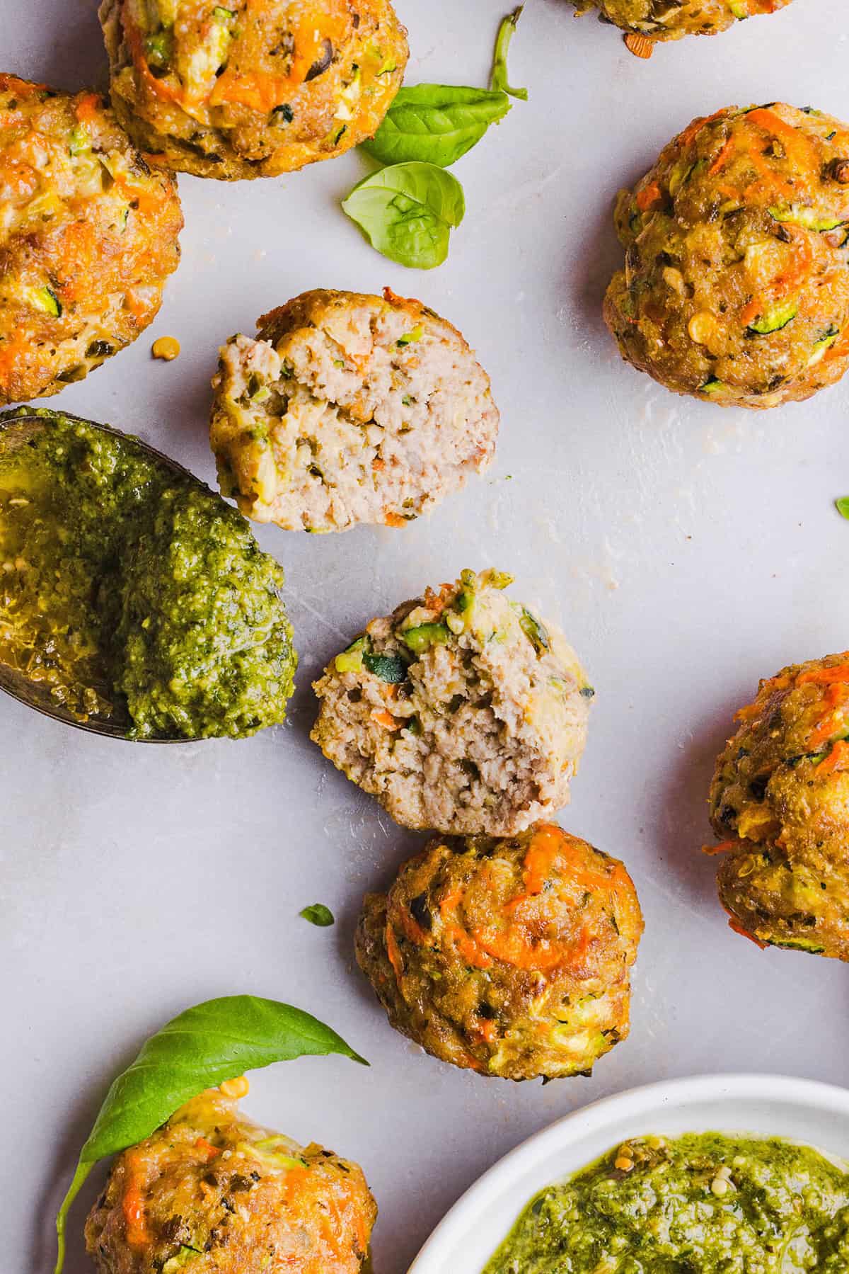 Mouthwatering Baked Chicken Pesto Meatballs made with tender ground chicken, garlicky basil pesto, fresh veggies and parmesan cheese. Juicy, flavorful and make the perfect weeknight meal served over pasta or with rice!