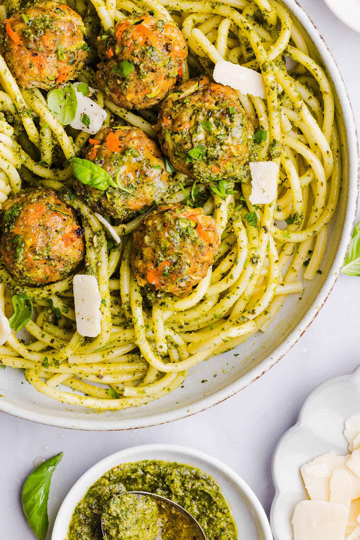 Mouthwatering Baked Chicken Pesto Meatballs made with tender ground chicken, garlicky basil pesto, fresh veggies and parmesan cheese. Juicy, flavorful and make the perfect weeknight meal served over pasta or with rice!