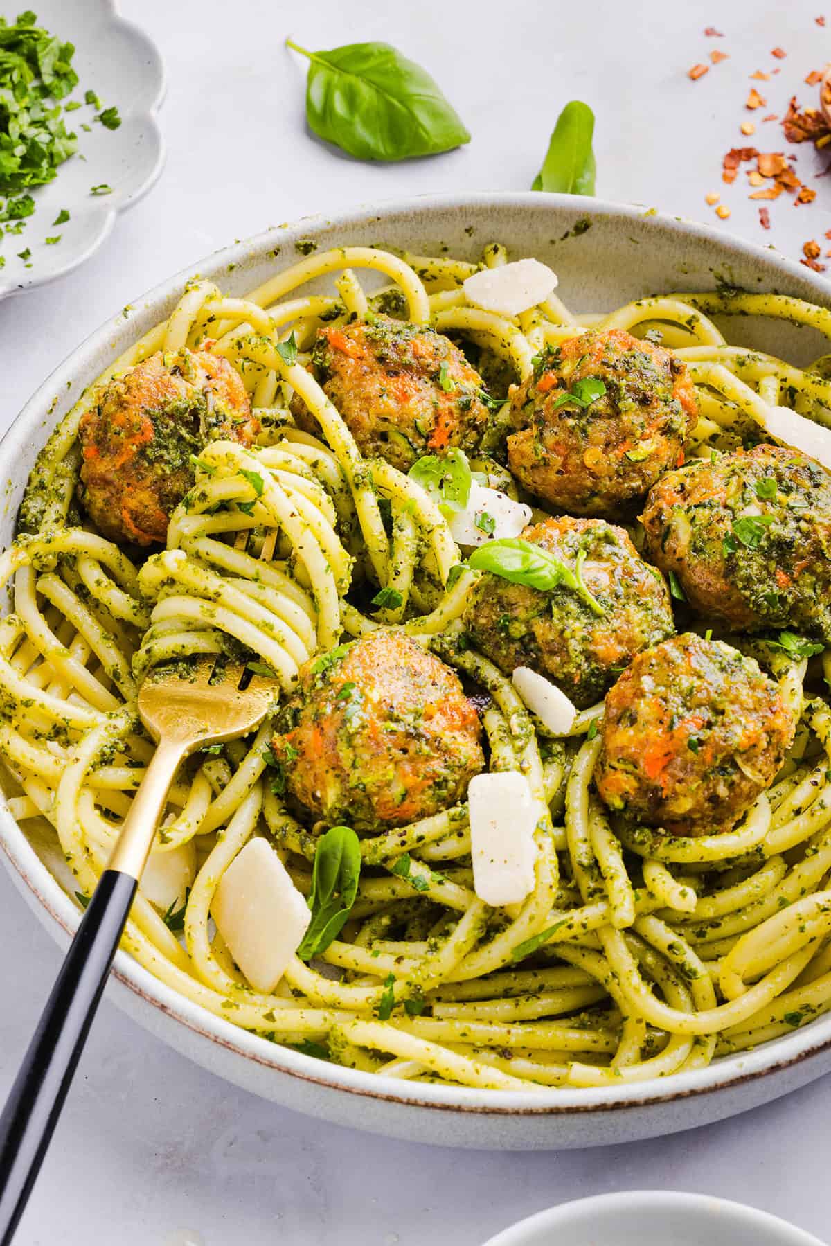 Mouthwatering Baked Chicken Pesto Meatballs made with tender ground chicken, garlicky basil pesto, fresh veggies and parmesan cheese. Juicy, flavorful and make the perfect weeknight meal served over pasta or with rice!