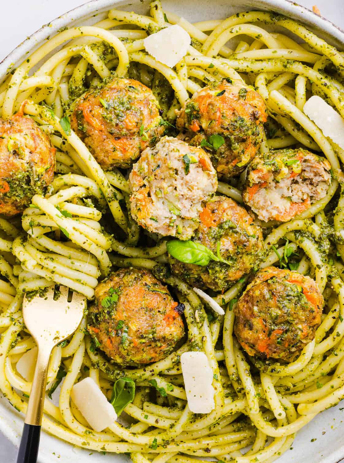 Mouthwatering Baked Chicken Pesto Meatballs made with tender ground chicken, garlicky basil pesto, fresh veggies and parmesan cheese. Juicy, flavorful and make the perfect weeknight meal served over pasta or with rice!