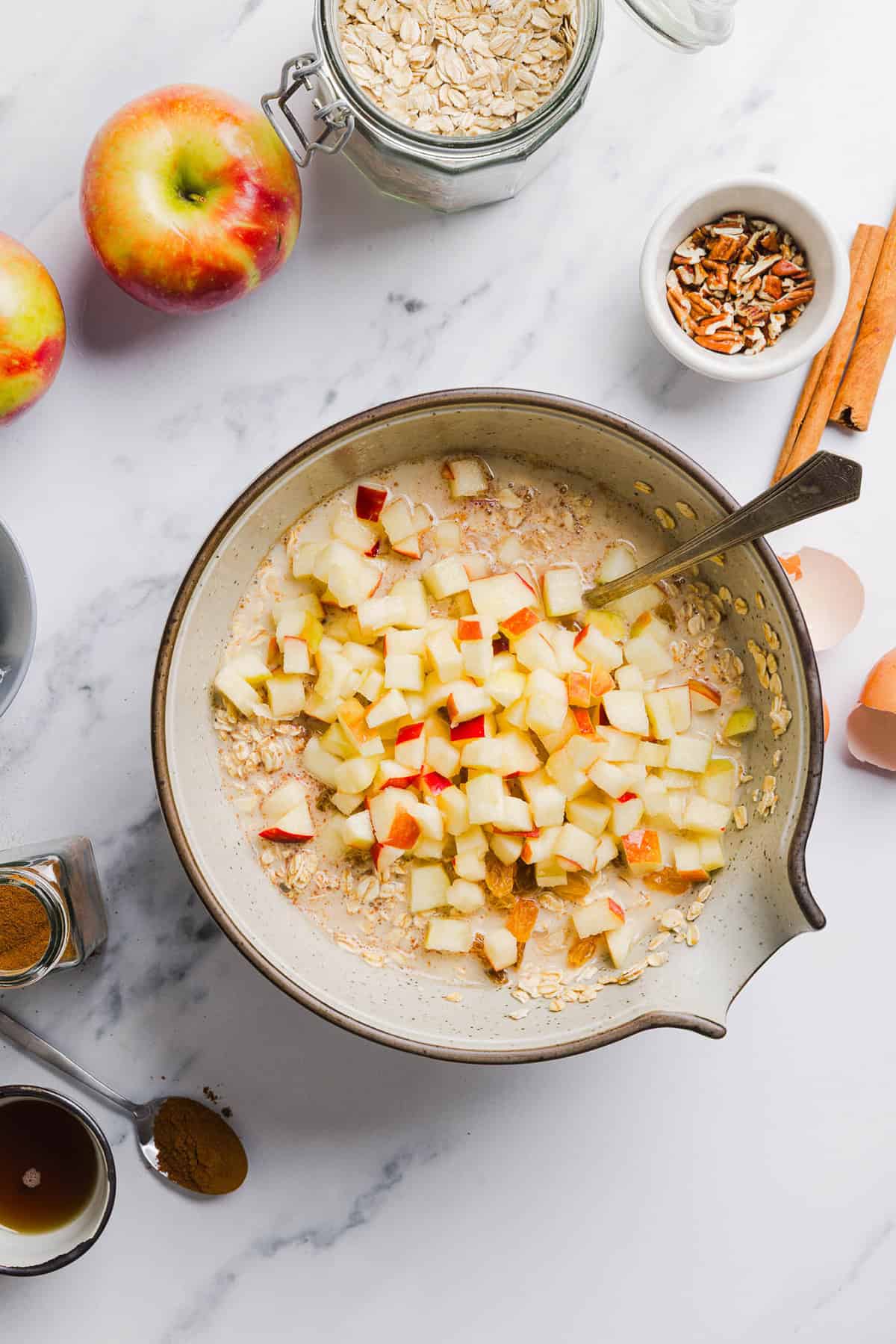This Apple Cinnamon Baked Oatmeal is a cozy breakfast made with wholesome oats, shredded apples, and warm spices while naturally sweetened with maple syrup and plump raisins! We also topped this with crunchy pecans and a delicious maple cream cheese glaze!