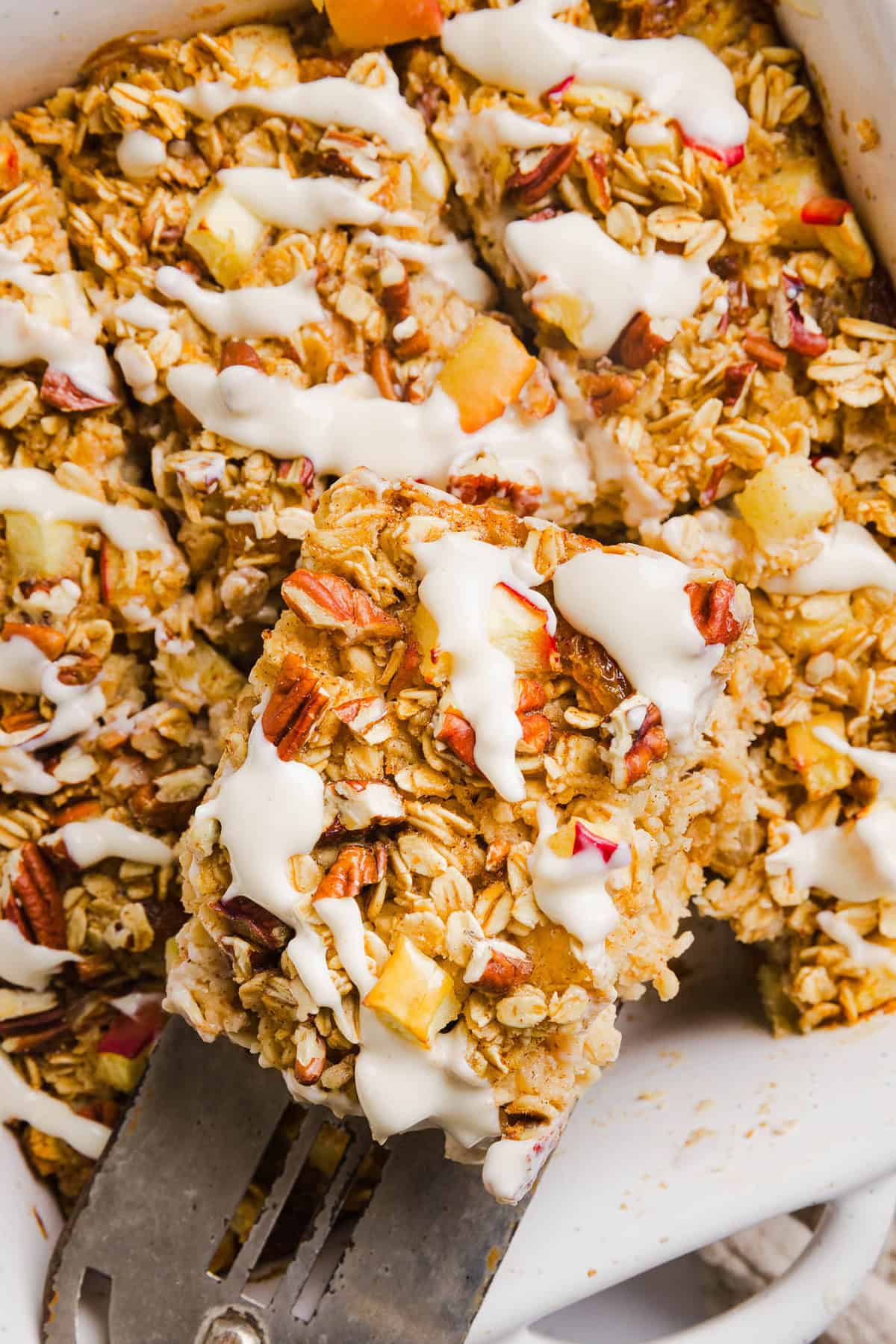This Apple Cinnamon Baked Oatmeal is a cozy breakfast made with wholesome oats, shredded apples, and warm spices while naturally sweetened with maple syrup and plump raisins! We also topped this with crunchy pecans and a delicious maple cream cheese glaze!
