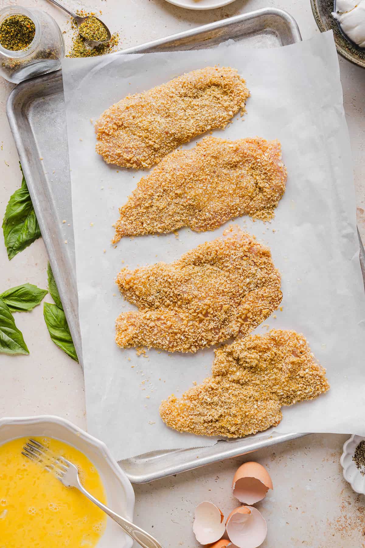 Easy Baked Chicken Parmesan made with tender juicy chicken, rich marinara sauce and melty cheese with a crisp coating that tastes delicious! This chicken is baked, not fried, and easily comes together in under 30 minutes!