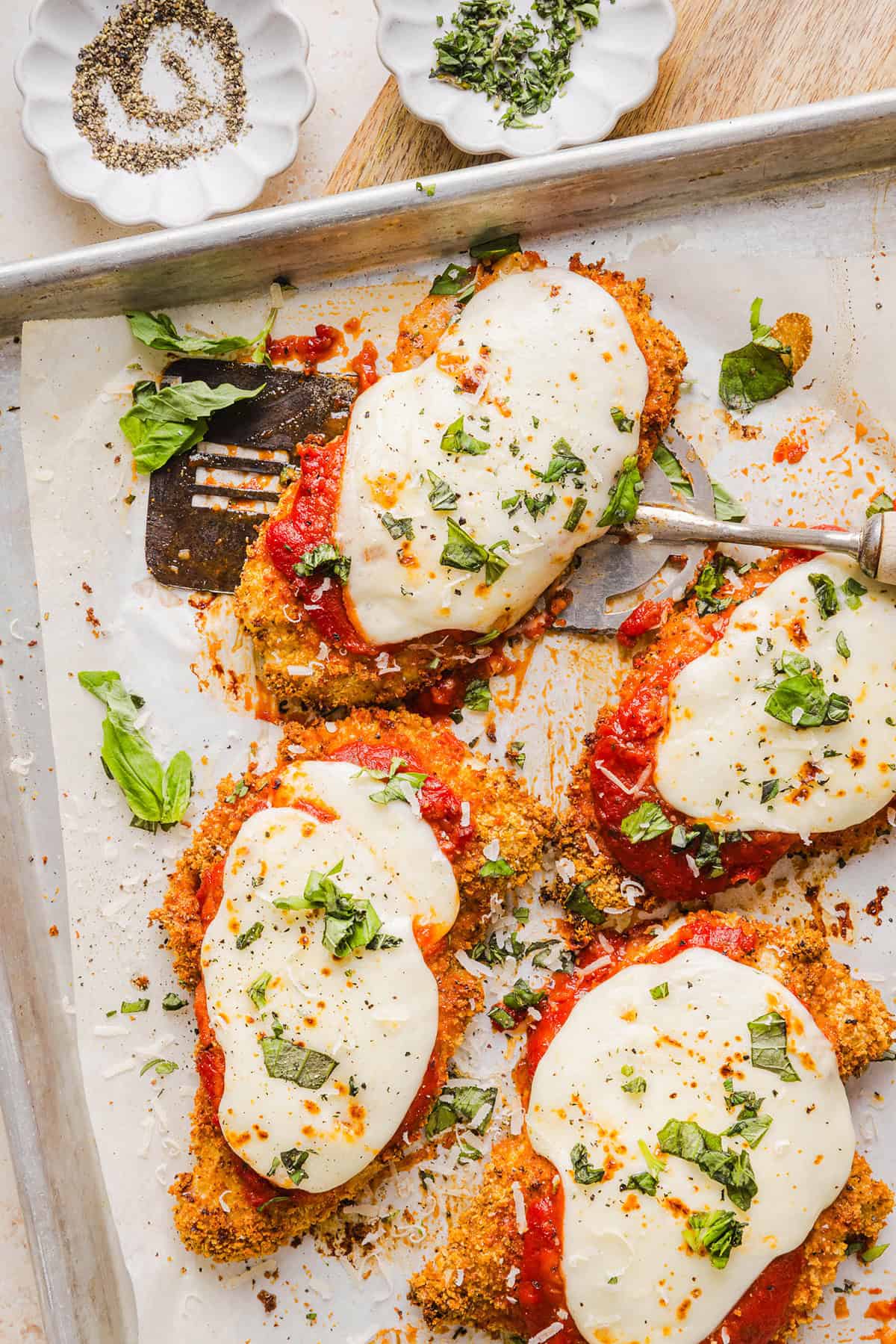 Easy Baked Chicken Parmesan made with tender juicy chicken, rich marinara sauce and melty cheese with a crisp coating that tastes delicious! This chicken is baked, not fried, and easily comes together in under 30 minutes!