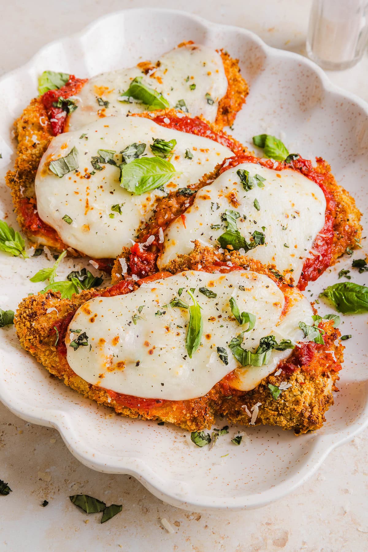 Easy Baked Chicken Parmesan made with tender juicy chicken, rich marinara sauce and melty cheese with a crisp coating that tastes delicious! This chicken is baked, not fried, and easily comes together in under 30 minutes!