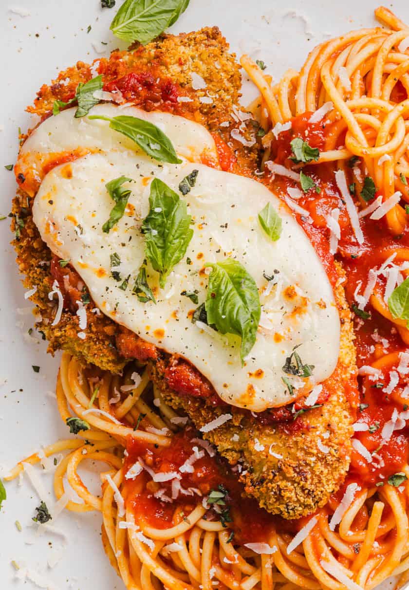 Easy Baked Chicken Parmesan made with tender juicy chicken, rich marinara sauce and melty cheese with a crisp coating that tastes delicious! This chicken is baked, not fried, and easily comes together in under 30 minutes!