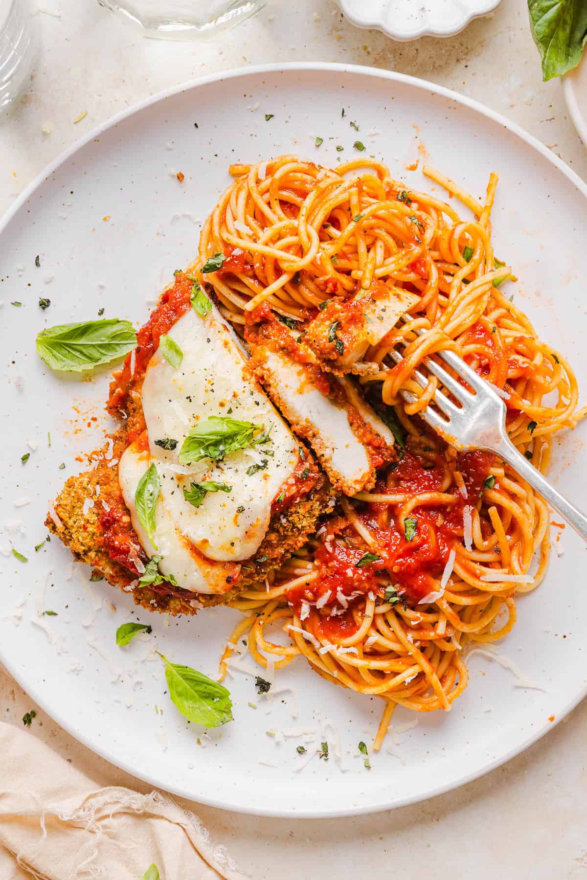 This Baked Chicken Parmesan is made with tender juicy chicken, rich marinara sauce and melty cheese with a crisp coating that tastes delicious! This chicken is baked, not fried, and easily comes together in under 30 minutes!
