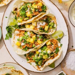 These Crock Pot Chicken Al Pastor Tacos are sweet, smoky, and incredibly flavorful! An easy slow cooker dinner made with juicy shredded chicken, fresh pineapple, chipotle peppers, and warm spices for a healthy, protein-packed dinner.