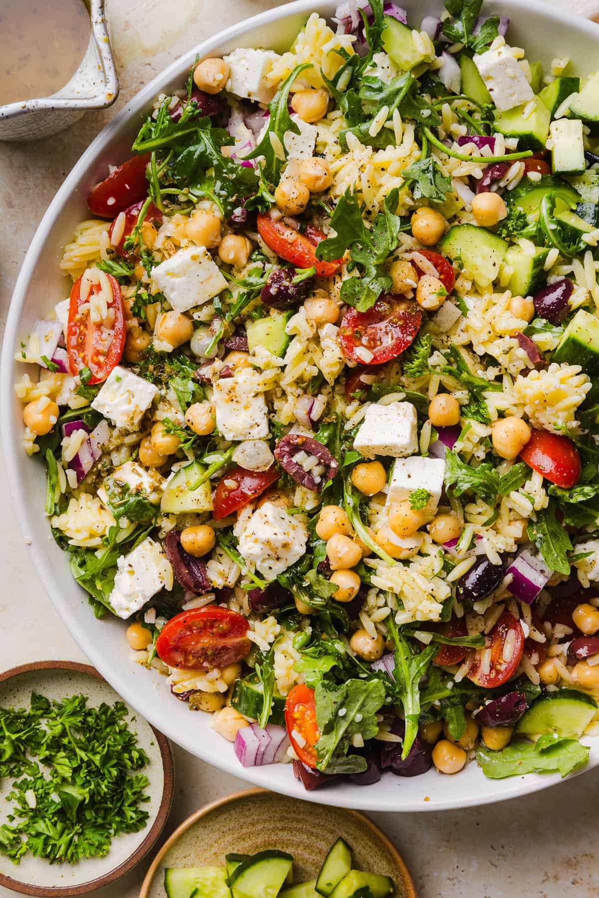 This Easy Greek Orzo Salad is packed with fresh veggies, chickpeas, feta, and the most delicious homemade lemon herb dressing. Perfect for meal prep, picnics, and summer cookouts!