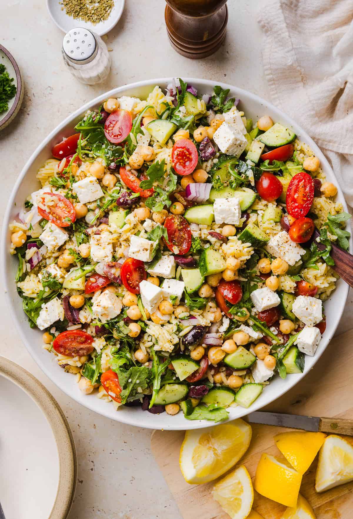 This Easy Greek Orzo Salad is packed with fresh veggies, chickpeas, feta, and the most delicious homemade lemon herb dressing. Perfect for meal prep, picnics, and summer cookouts!