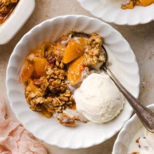 This Healthy Peach Crisp recipe is made with juicy fresh peaches and a wholesome oat pecan crumble naturally sweetened with maple syrup. An easy summer dessert that is warm, cozy, and perfect with vanilla ice cream!