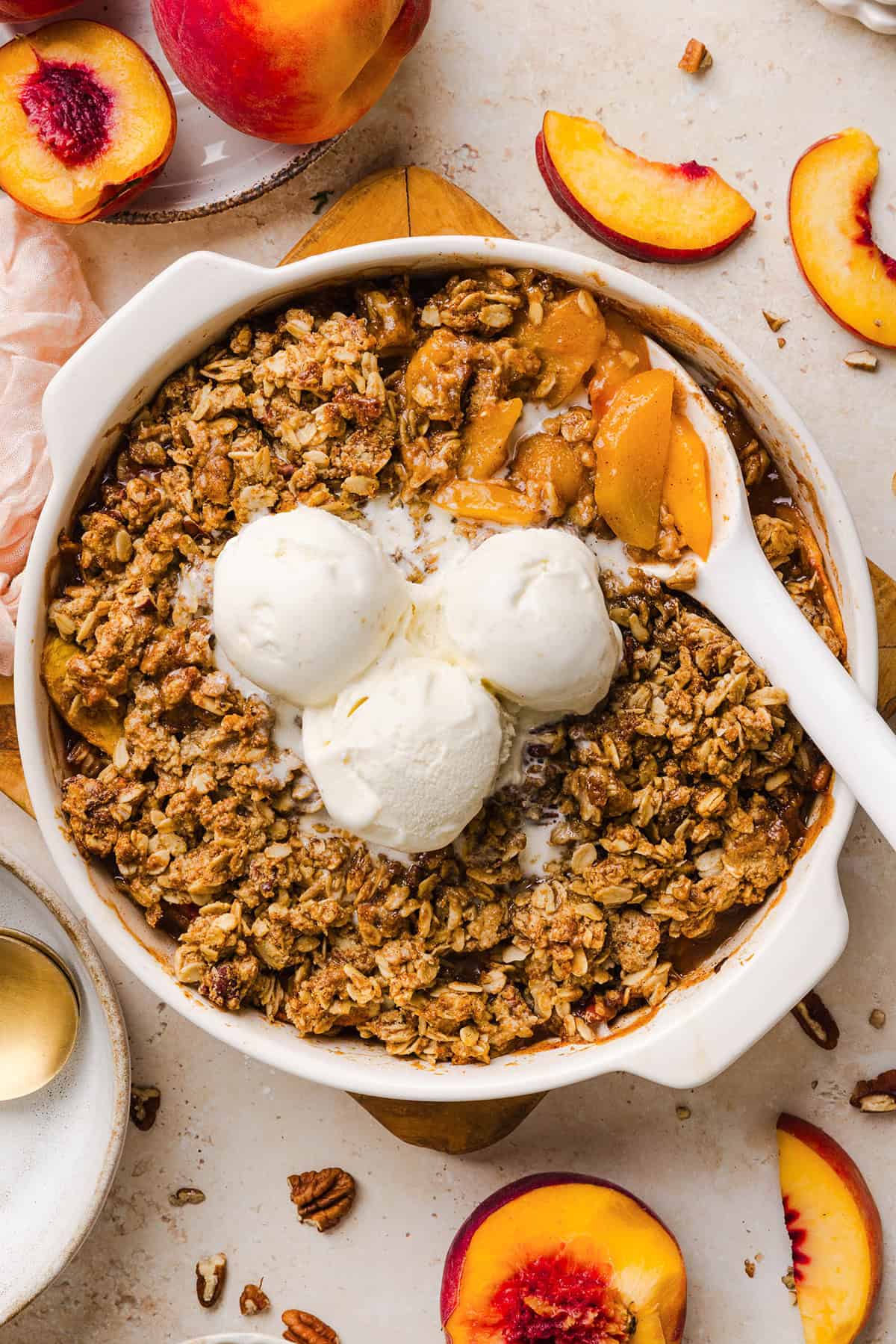 This Healthy Peach Crisp recipe is made with juicy fresh peaches and a wholesome oat pecan crumble naturally sweetened with maple syrup. An easy summer dessert that is warm, cozy, and perfect with vanilla ice cream!