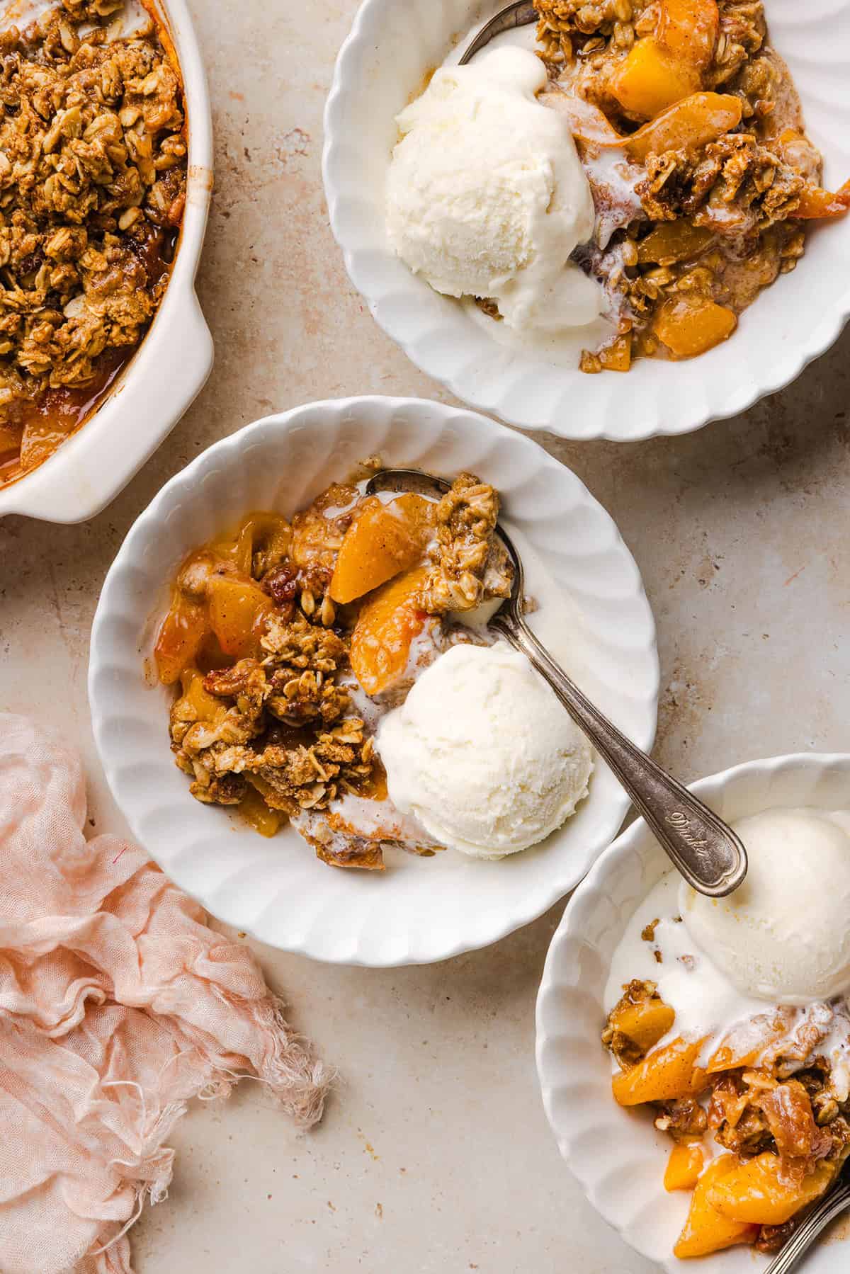 This Healthy Peach Crisp recipe is made with juicy fresh peaches and a wholesome oat pecan crumble naturally sweetened with maple syrup. An easy summer dessert that is warm, cozy, and perfect with vanilla ice cream!